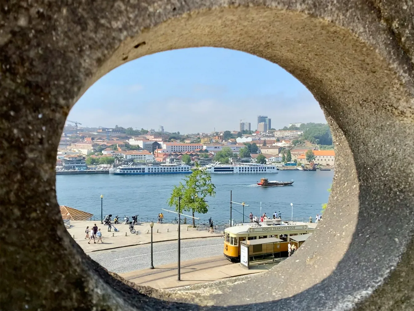 picturesque view of Porto captured through a stone arch, highlighting the charm and historic significance of the city. ShinTours luxury tours offer personalized explorations of Porto’s hidden gems, perfect for luxury travelers.