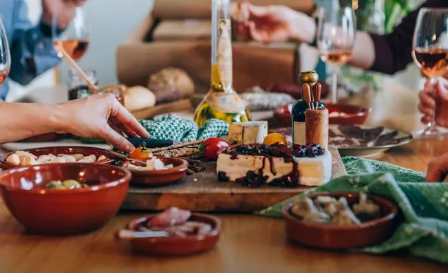 Enjoy the traditional Portuguese culinary experience of tapas sharing at A Merendinha do Arco Bandeira in Lisbon with Shin-Tours Luxury Tours, indulging in a variety of local flavors."