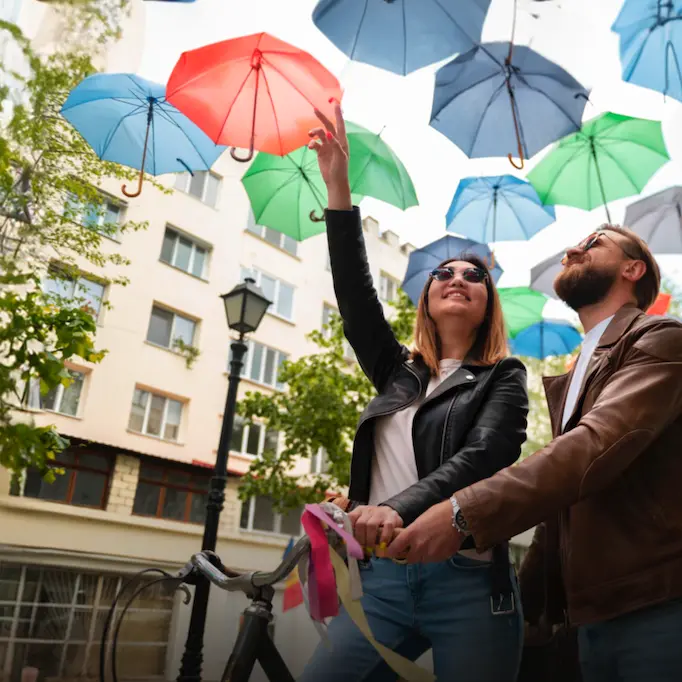 Couple enjoying colorful umbrellas on a sunny day in Spain, reflecting vibrant spring weather